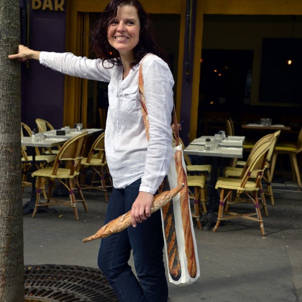Sac à baguette porté par une femme devant une terrasse - Sac à pain made in France - Maron Bouillie Paris