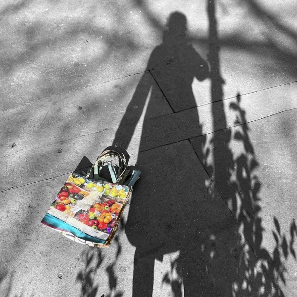 Shadow of a woman carrying the Peppers–Tomatoes market tote bag by Maron Bouillie - Original shopping bag made in France Shadow of a woman carrying the Peppers–Tomatoes market tote bag by Maron Bouillie - Original shopping bag made in France