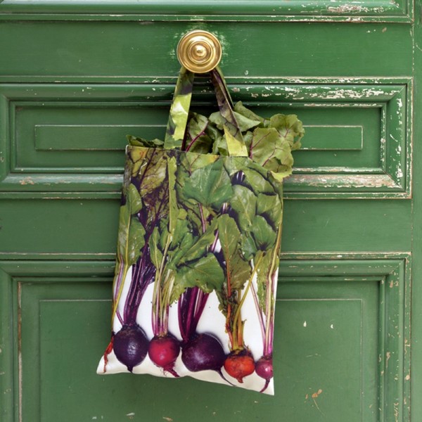 Multicolored beetroot bag hanging on the handle of a green door. Maron Bouillie shopping bags made in France Multicolored beetroot bag hanging on the handle of a green door. Maron Bouillie shopping bags made in France