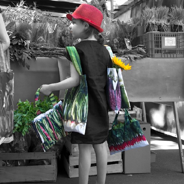 Little girl at the Paris street market carrying Maron Bouillie's vegetable shopping bags. Little girl at the Paris street market carrying Maron Bouillie's vegetable shopping bags.