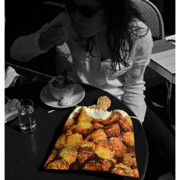 Femme avec le sachet de chouquettes Maron Bouillie à une terrasse de café à Paris