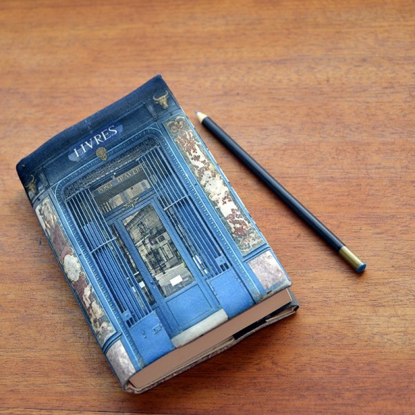 Couvre livre Boutique de Paris Librairie bleue posé sur une table en bois - Maron Bouillie made in France Couvre livre Boutique de Paris Librairie bleue posé sur une table en bois - Maron Bouillie made in France