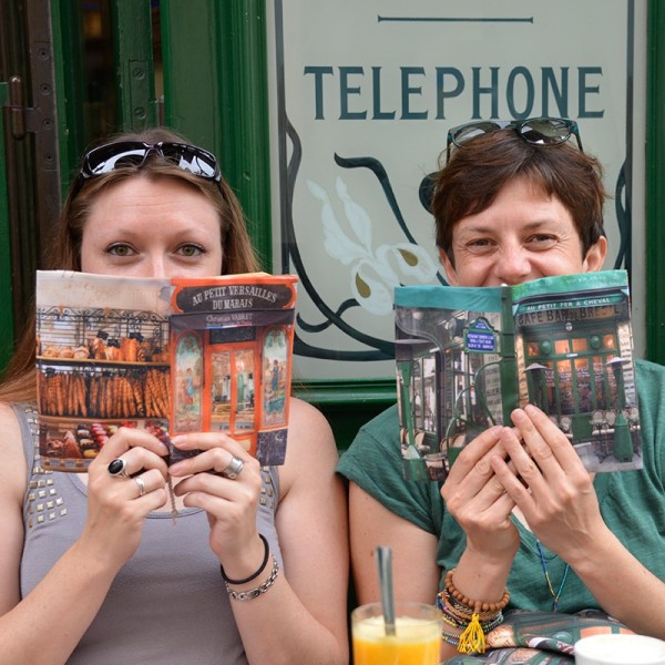 Protèges livre en tissu boutiques de Paris dans les mains de deux jeune fille en terrasse - Maron Bouillie made in France