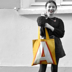 Letter A bag carried by a laughing young girl - French tote bag design by Maron Bouillie