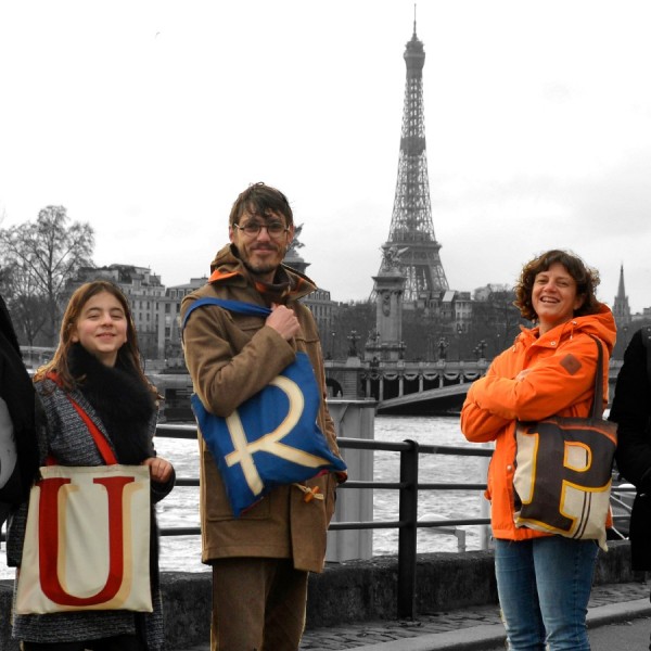 3 personnes à Paris avec la Tour Eiffel au loin portant chacune un sac initiale U, R et P Sac shopping Maron Bouillie 3 personnes à Paris avec la Tour Eiffel au loin portant chacune un sac initiale U, R et P Sac shopping Maron Bouillie