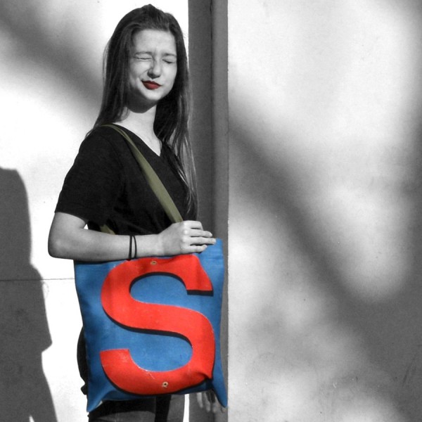 Letter S bag carried by a young girl who winks - French tote bag design by Maron Bouilli