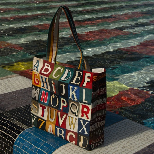 Alphabet shopping bag with colored letters placed on the edge of a pond - Maron Bouillie Paris