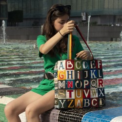 Jeune fille assise au bord d'un bassin avec le cabas shopping alphabet lettres de Maron Bouillie made in France