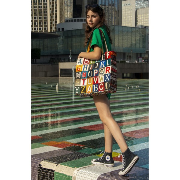 Young girl standing at the edge of a pool with the shopping bag alphabet letters by Maron Bouillie made in France
