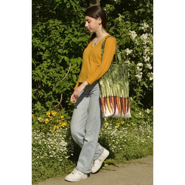 Young Lady carrying the large multicolored Carrots vegetable shopping bag from Maron Bouillie.  Market tote made in France Young Lady carrying the large multicolored Carrots vegetable shopping bag from Maron Bouillie.  Market tote made in France