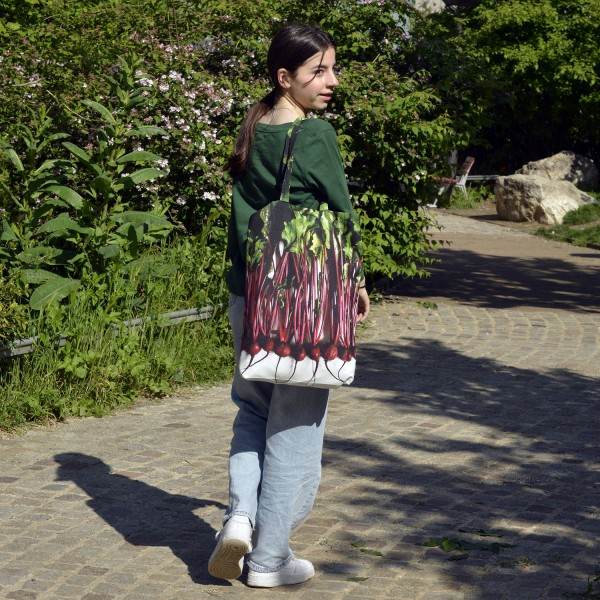 Young girl walking in a garden with the Maron Bouillie beetroot vegetable market tote bag.