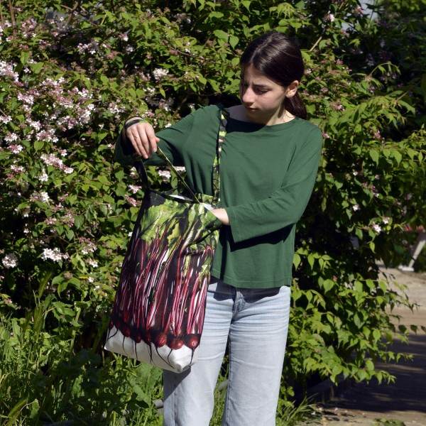 Jeune fille dans un jardin avec le grand sac de course légumes betteraves de Maron Bouillie.