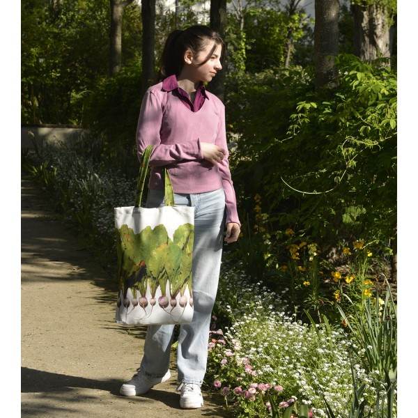 Young girl walking in a garden with the Maron Bouillie turnips vegetable market tote bag.
