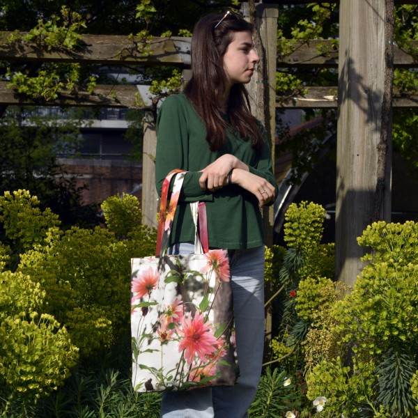 Jeune fille dans un jardin portant le sac fleur modèle Dahlia de Maron Bouillie - made in France