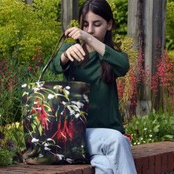 Young girl sitting in a garden wearing the Royal Fuchsia Flower Tote Bag by Maron Bouillie Made in France 2