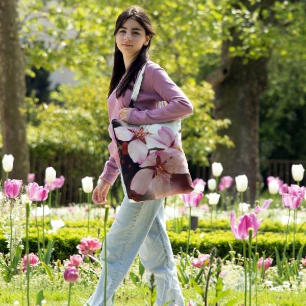 Jeune fille dans un jardin avec des tulipes portant le sac imprimé fleur de cerisier d'hiver de Maron Bouillie made in France