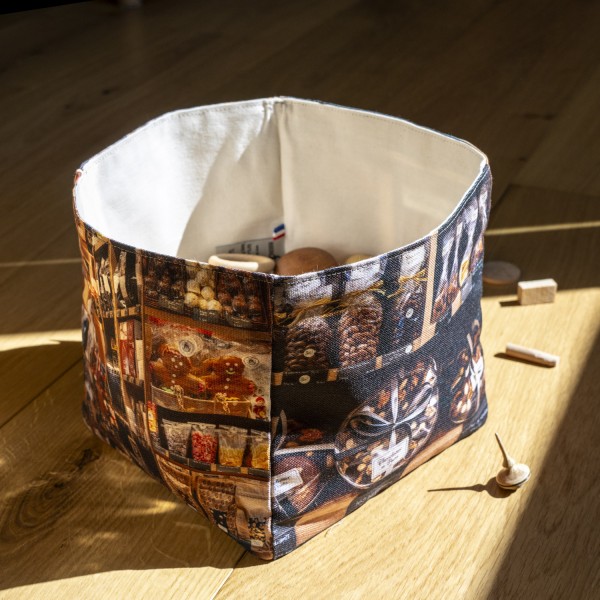 Chocolatier de Paris home goods basket placed on a wooden table with spinning tops - Maron Bouillie