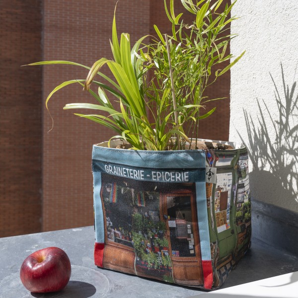 Fabric basket from the Paris vintage shop Graineterie du marché Maron Bouillie with a green plant inside.