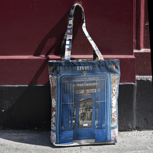 Reusable shopping bag Paris Bookstore Livres Au pont traversé posed in front of a red door. Maron Bouillie made in France.