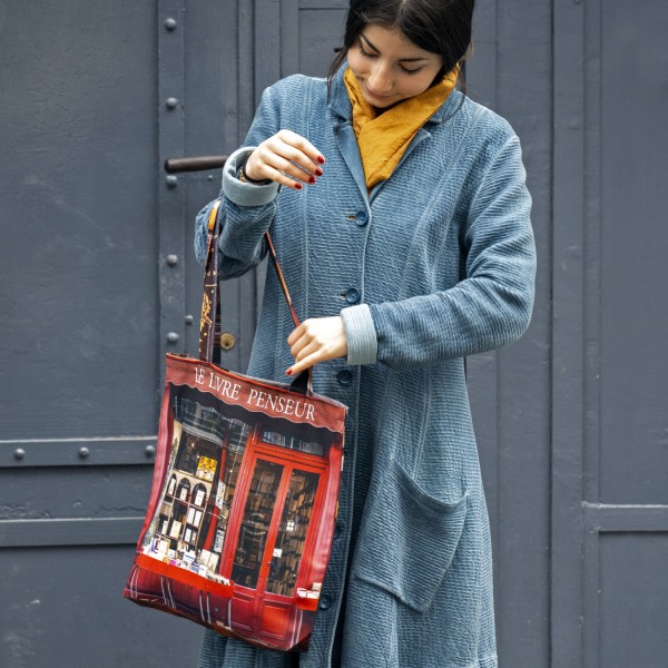 jeune fille devant une porte grise avec le Tote bag made in Paris librairie Le livre penseur de Maron Bouillie.