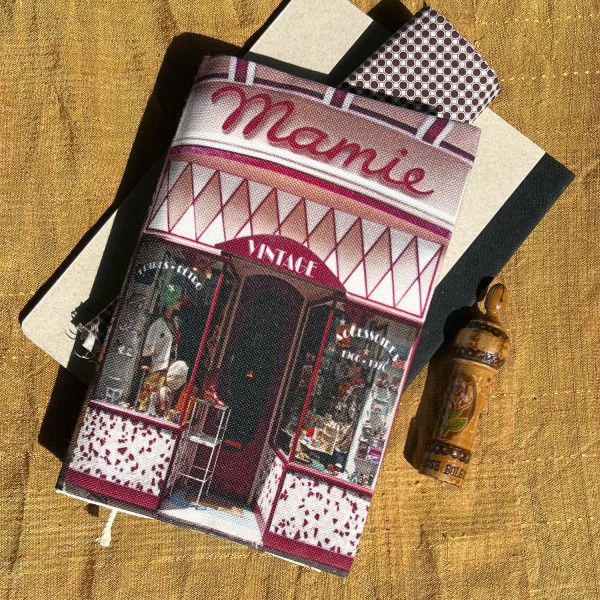 Protège-livre de poche Boutique de Paris Mamie mode vintage posé sur une table - Maron Bouillie made in France