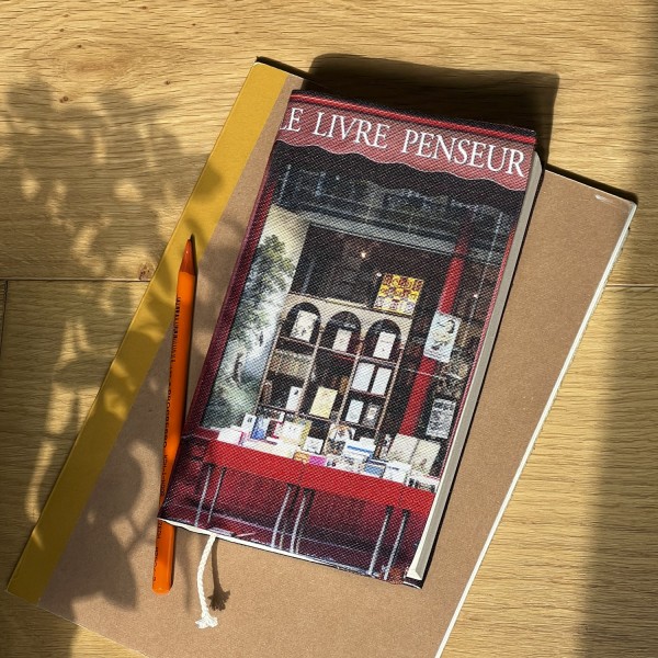 Book cover from Paris Bookstore Le livre penseur, placed on a table with notebooks and shadows - Maron Bouillie, made in France