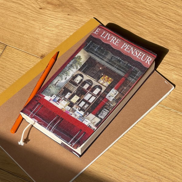 Book cover from Paris Bookstore Le livre penseur, placed on a table with notebooks and shadows - Maron Bouillie, made in France