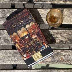 Luthier de Paris paperback book cover on a café table - Maron Bouillie, made in France